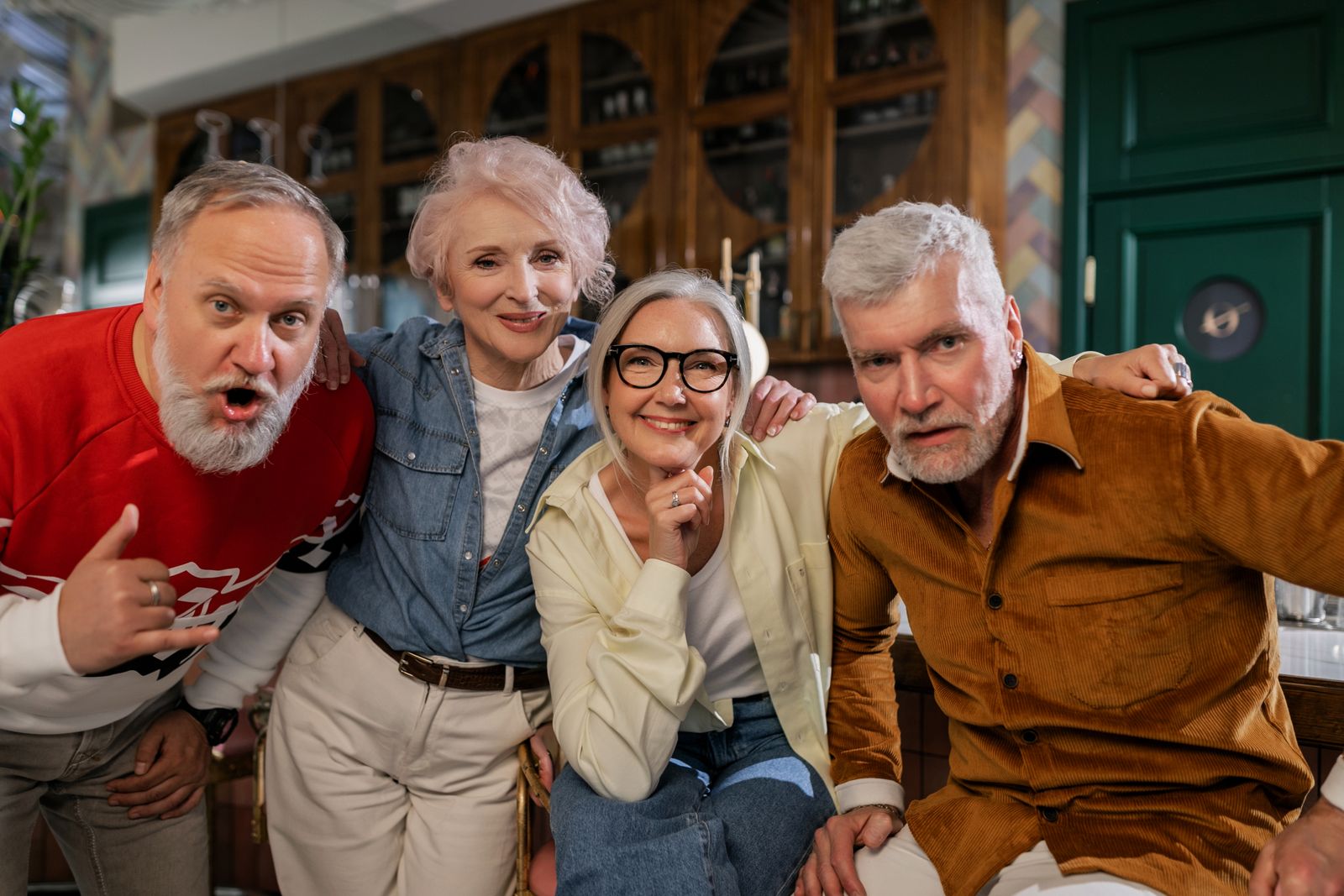 Groupe d'aînés souriants et complices, partageant un moment joyeux ensemble